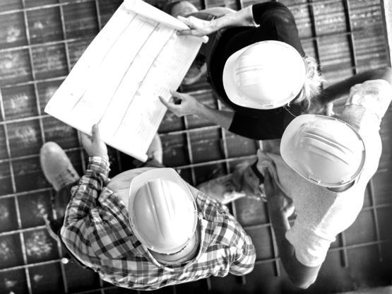 Building contractors on site in hard hats - DUAL Oliva